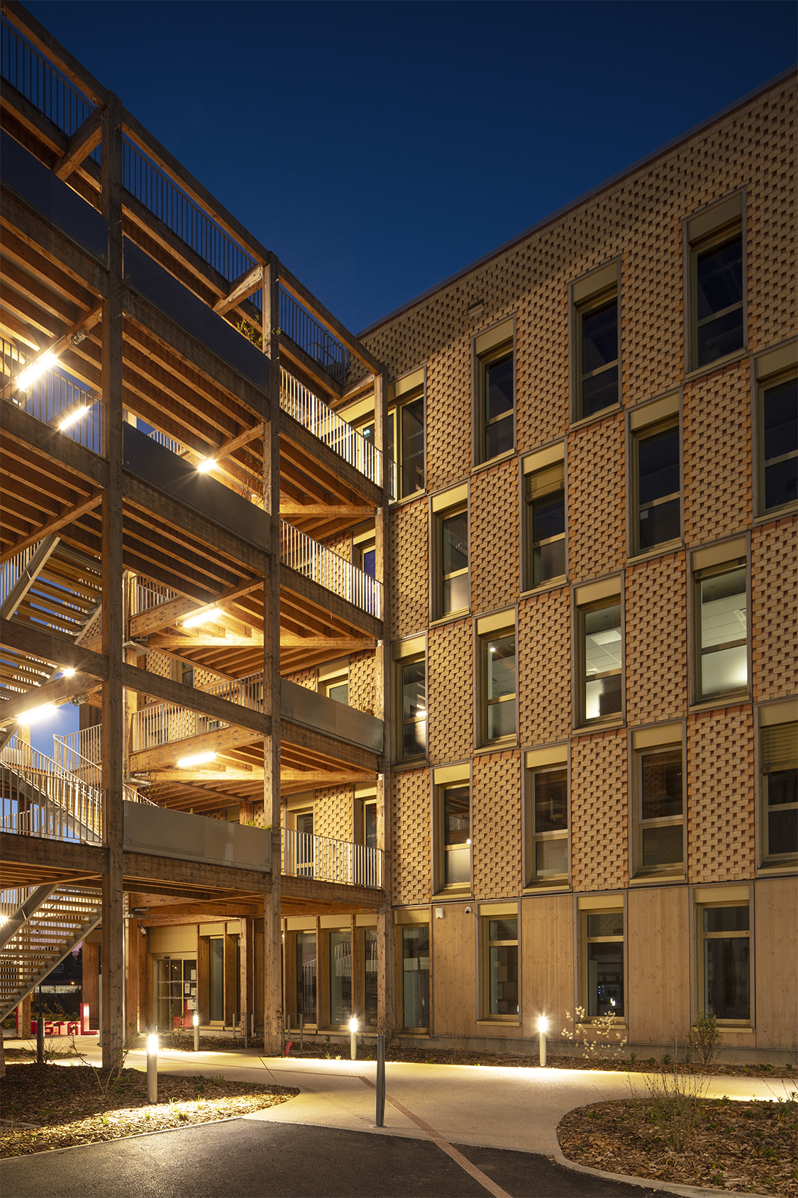 La faille en bois est conçu comme un echaffaudage qui relie les deux bâtiments avec un jeu de terrasses. / Edouard Decam - CoCo architecture et Scapa architectes - L'oustaL, Périgueux, 2025