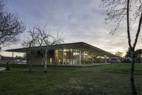 Pole culturel et festif BOMA_vue extérieure du bâtiment neuf s'ouvrant sur le paysage de la grande prairie / Jean Francois Tremege - Marjan Hessamfar et Joe Vérons architectes - Pôle culturel et festif BOMA, Saint-Denis-de-Pile, 2021