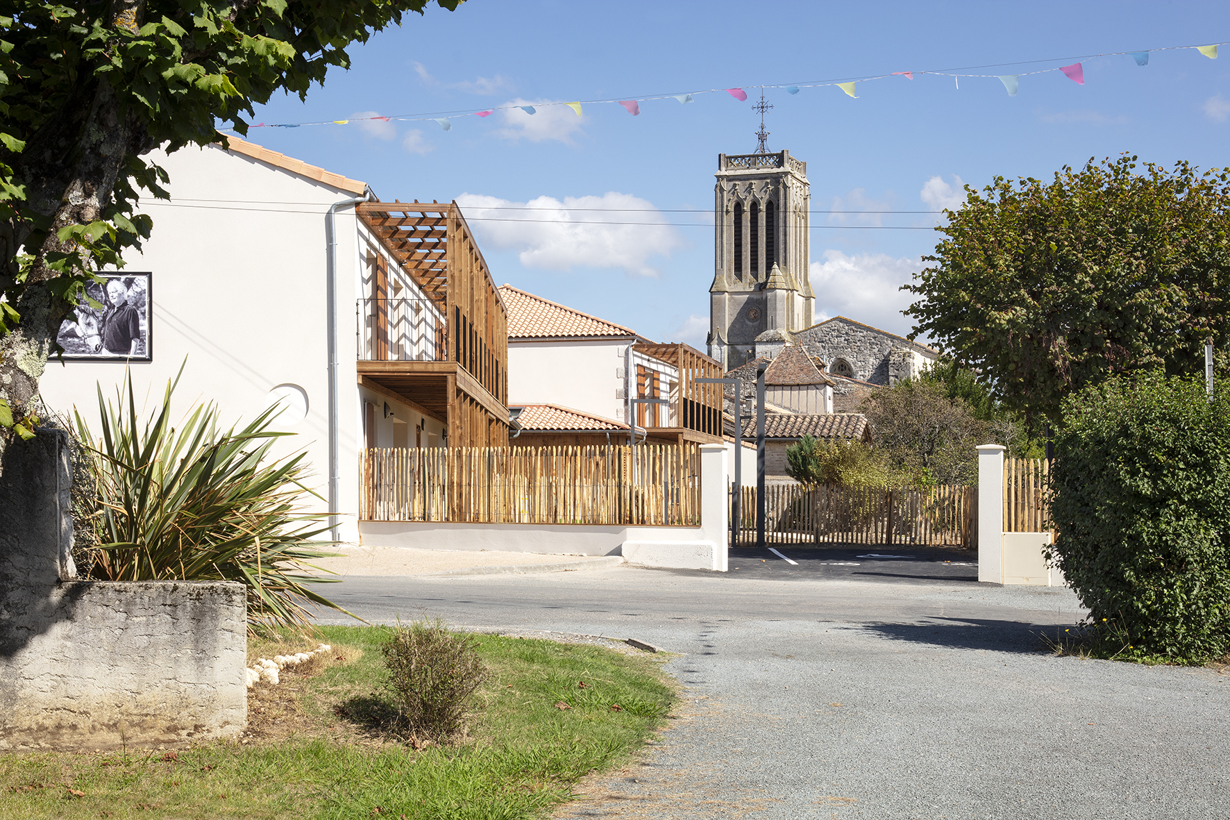 Vue du projet depuis l'entrée du village / Agnès Clotis - Besson Bolze - Logements séniors et maison commune à la Sauvetat-du-Dropt - 01 octobre 2025