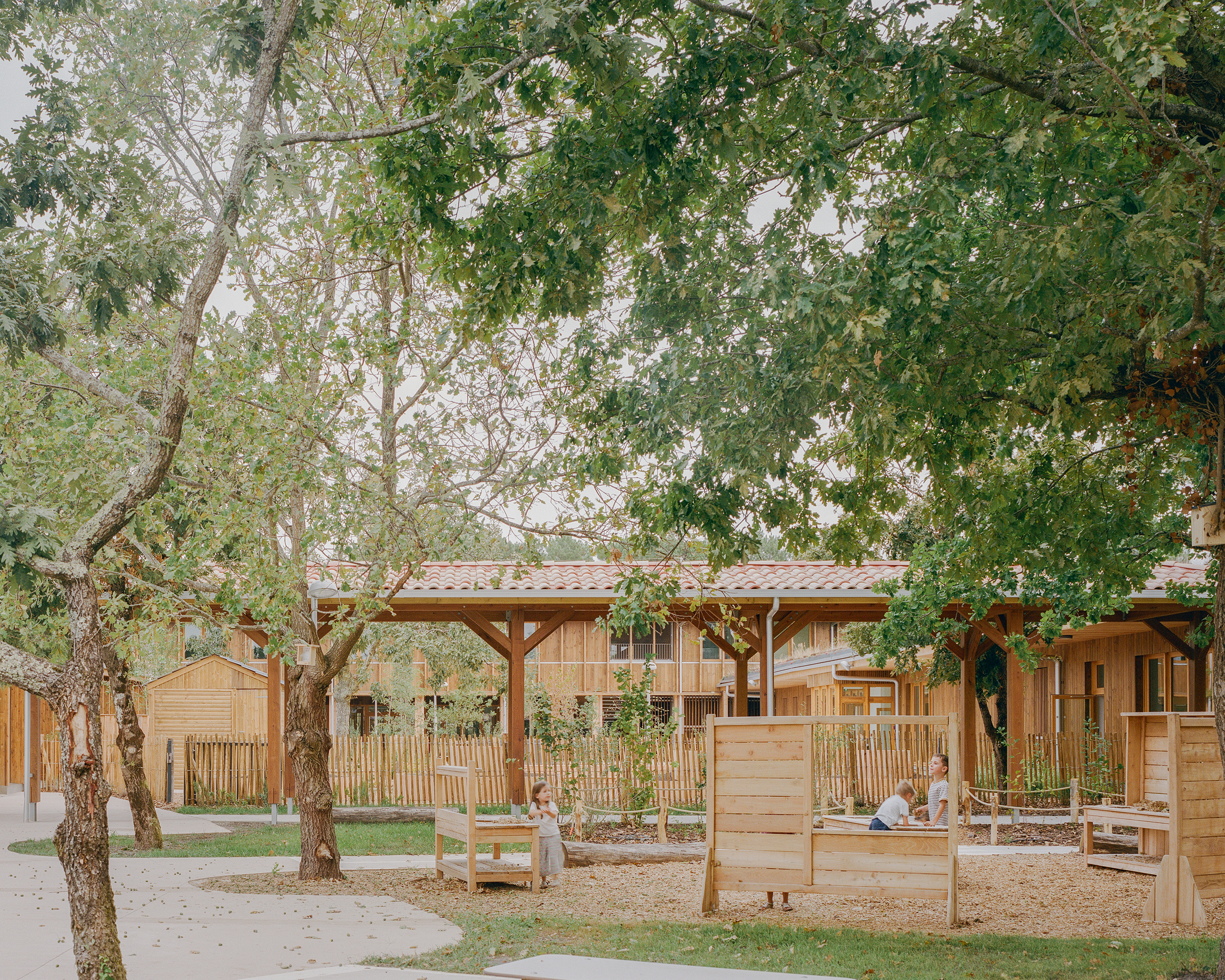 La cour maternelle depuis le bois / Charles Bouchaïd - Agence Ferron Monnereau + Besson Bolze - Groupe scolaire Robert et Elisabeth Badinter - Audenge - 18 août 2025