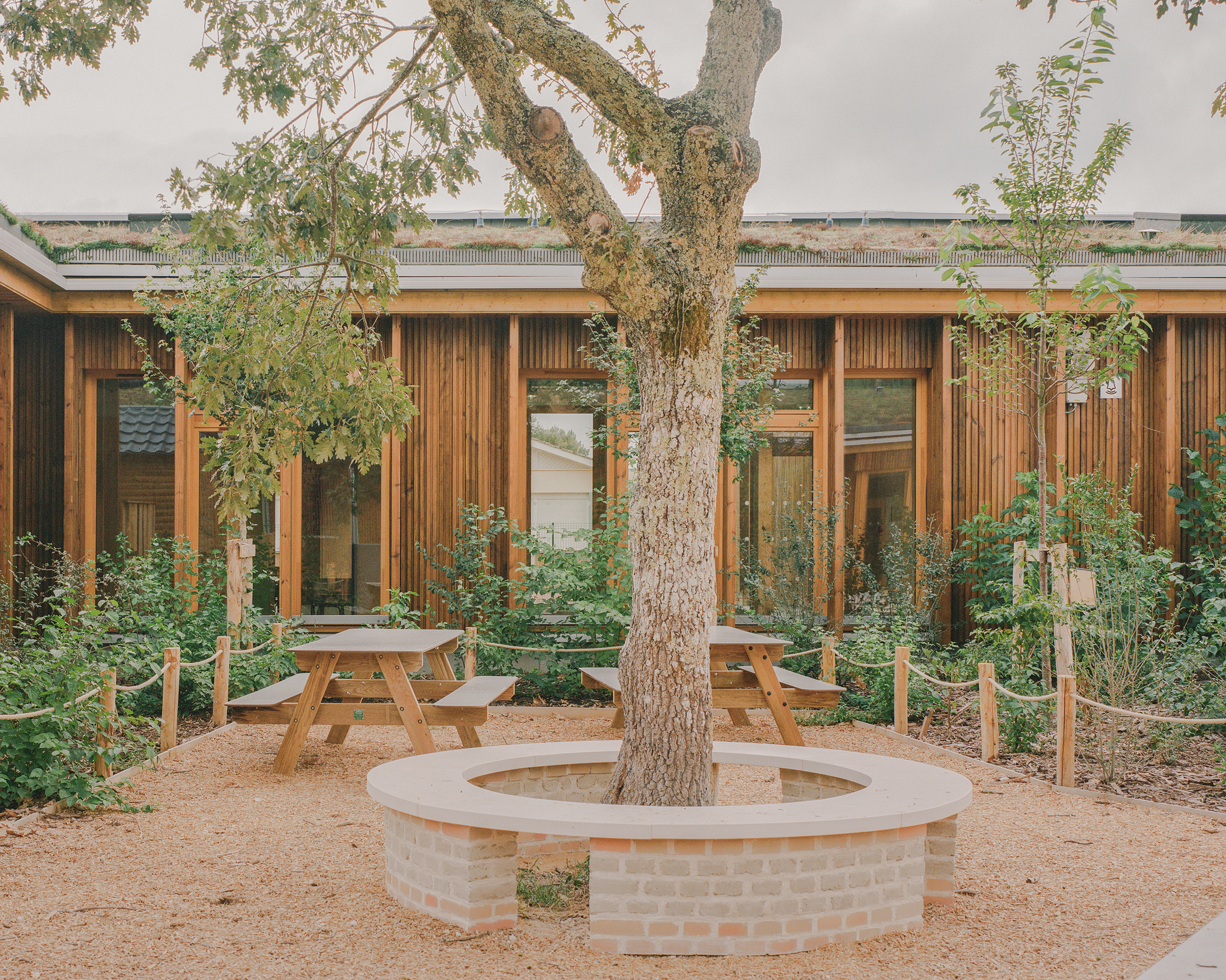 Banc construit en terre crue du Barp lors d'ateliers participatifs avec les enfants de l'ALSH / Charles Bouchaïd - Agence Ferron Monnereau + Besson Bolze - Groupe scolaire Robert et Elisabeth Badinter - Audenge - 18 août 2025
