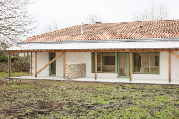Vue depuis le jardin sur le nouveau préau partagé / Agnès Clotis