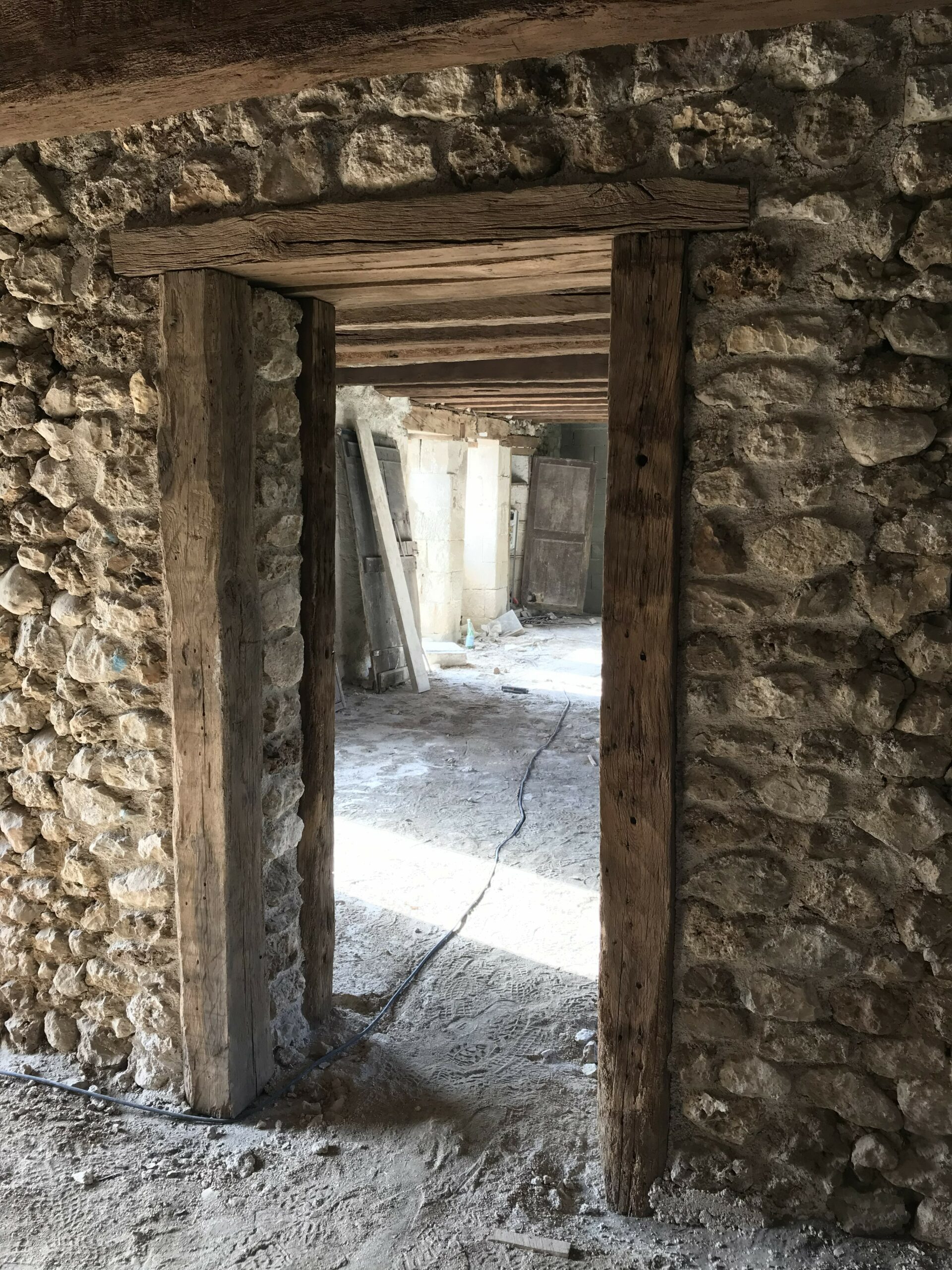 Intérieur - passage avec anciens chevrons et murs pierre, aérogommage des solives / Photo de Frédérique Ivanès, architecte, REHABILITATION D'UNE LONGERE POITEVINE A LA CROIX SIAUME, octobre 2025