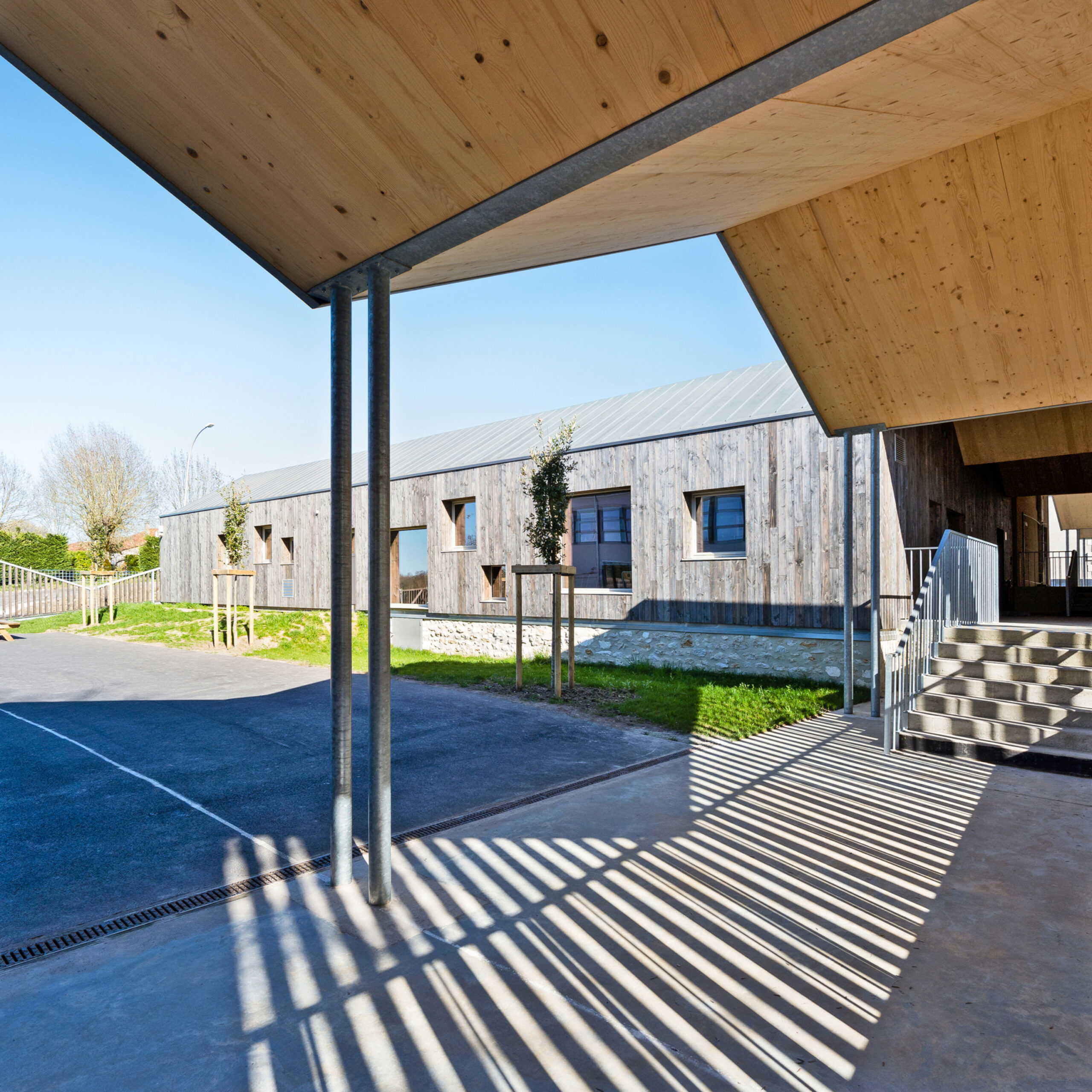 Le préau se déplie, abritant la liaison entre bâtiments / Julia Hasse – Atelier du Trait – Groupe Scolaire de Brossac, Brossac, 2022