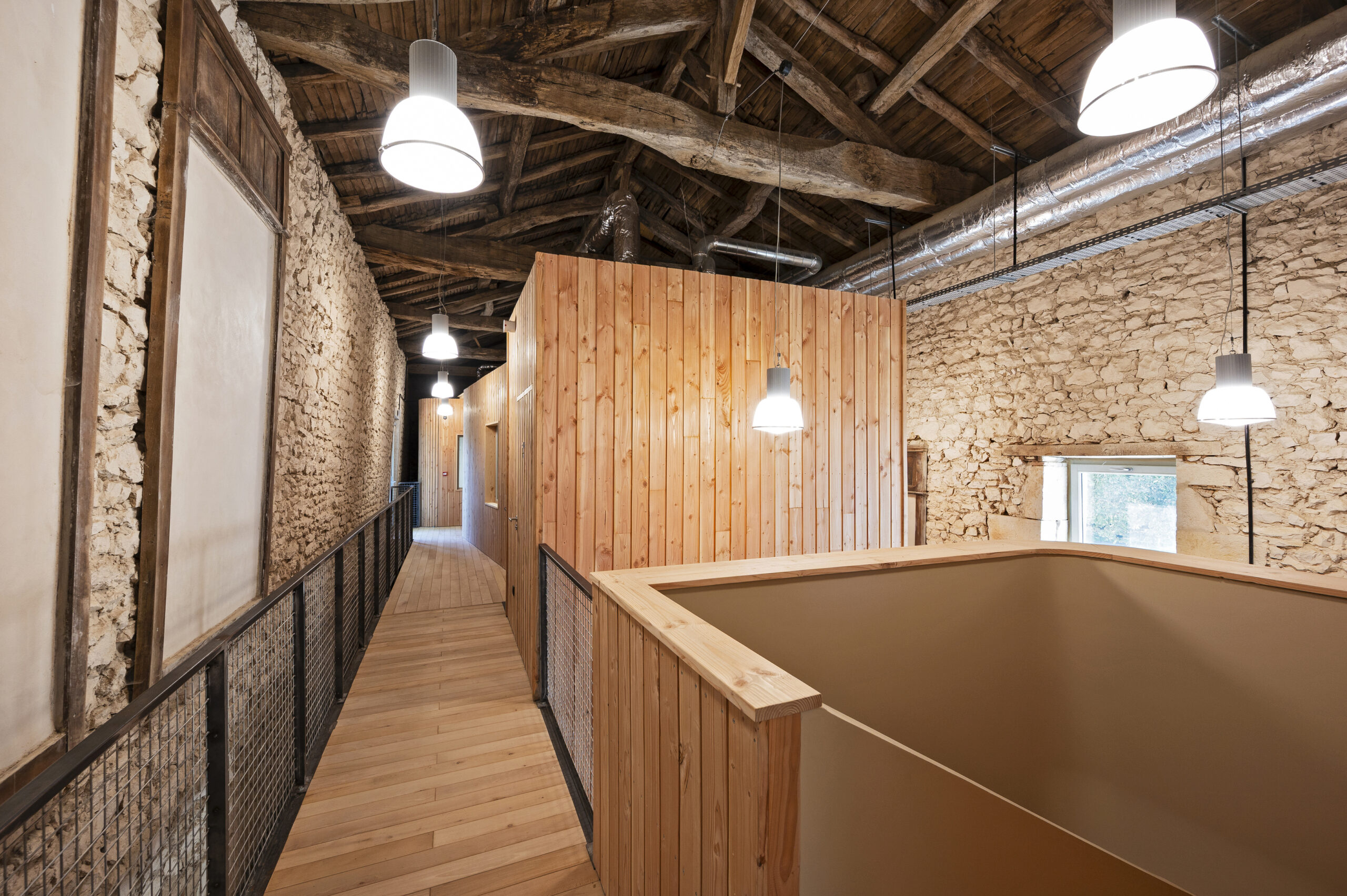 La grange tempérée accueille des lieux de travail confortables / Julia Hasse – Atelier du Trait - Création de studios meublés et espaces de co-working / réunion, Saint-Pierre d’Exideuil, 2024
