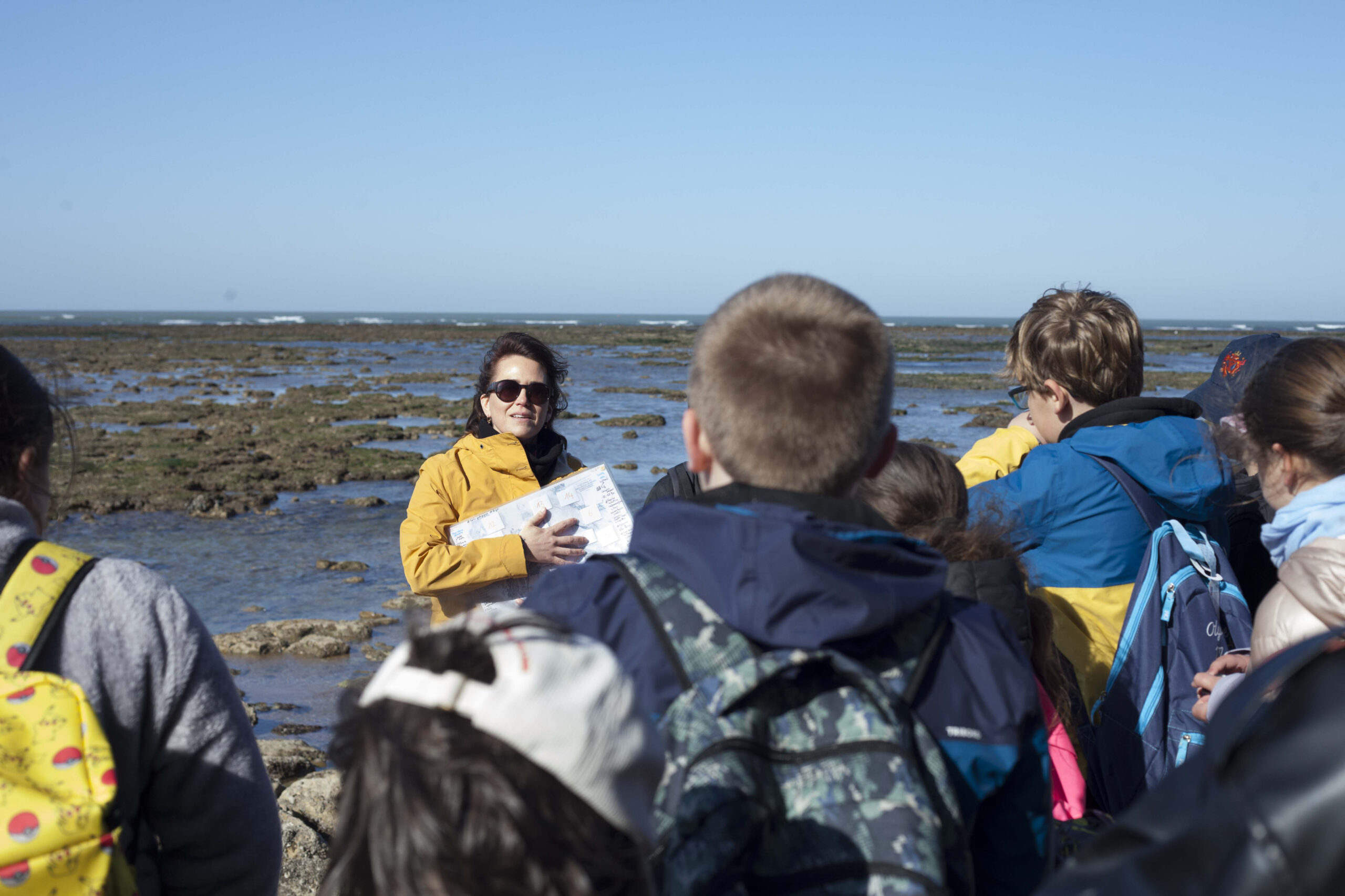 Barbara Laleve, chargée des zones humides au SMIDDEST, raconte aux enfants la vie du plateau rocheux du phare de Cordouan. / atelier TçPç - Atlas de l'estuaire, CdC Médoc Atlantique, 2025